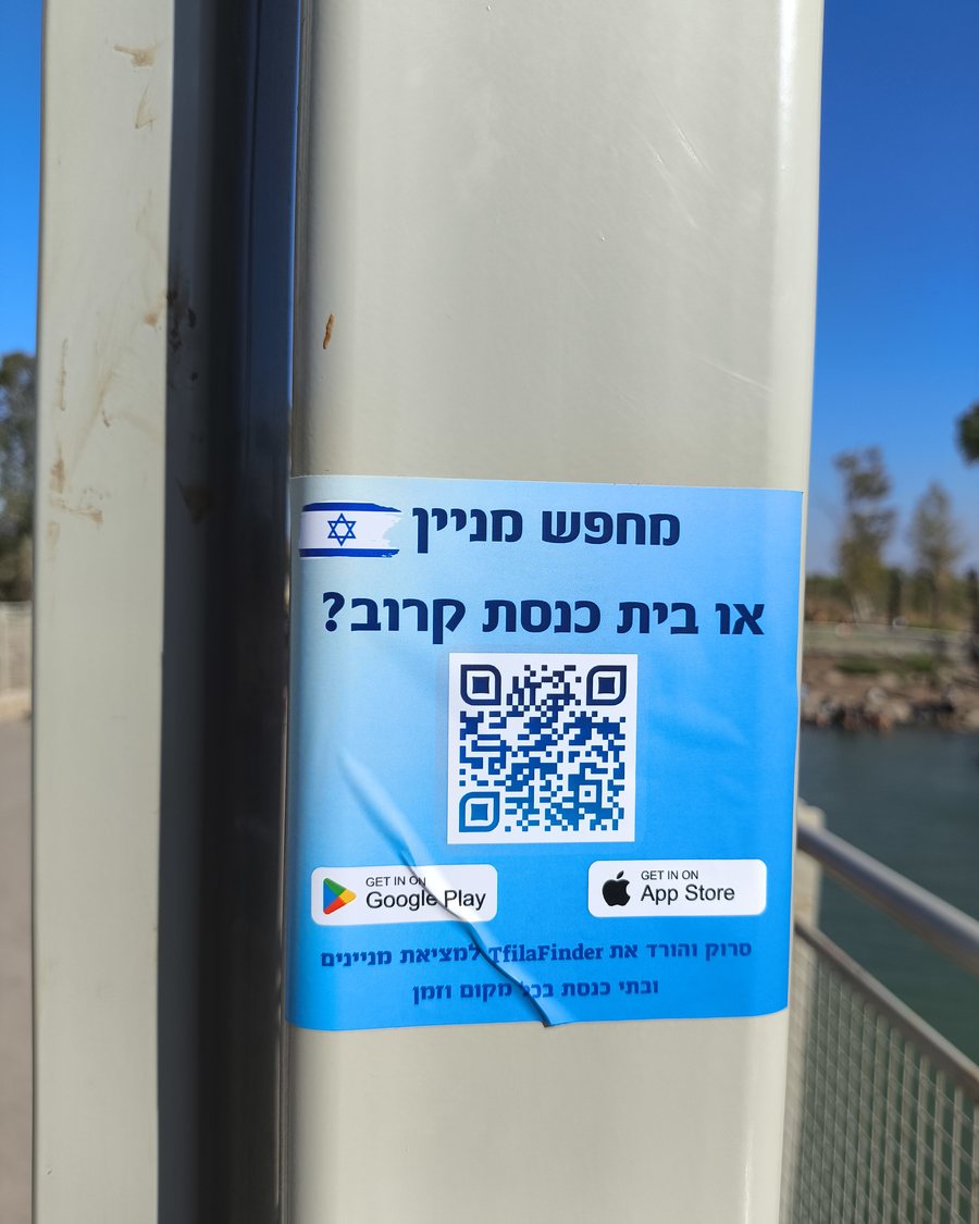 מדבקה כחולה על עמוד ליד המים: מחפש מניין או בית כנסת קרוב? עם קוד QR להורדת האפליקציה